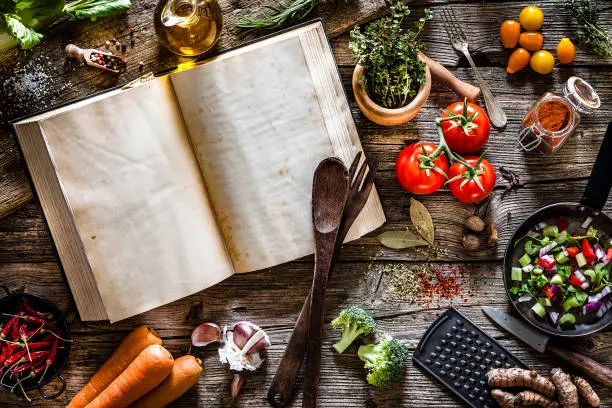 A group of friends joyfully cooking together in a kitchen, embodying the spirit of community and culinary exploration fostered by Vegan Cookbook Haven